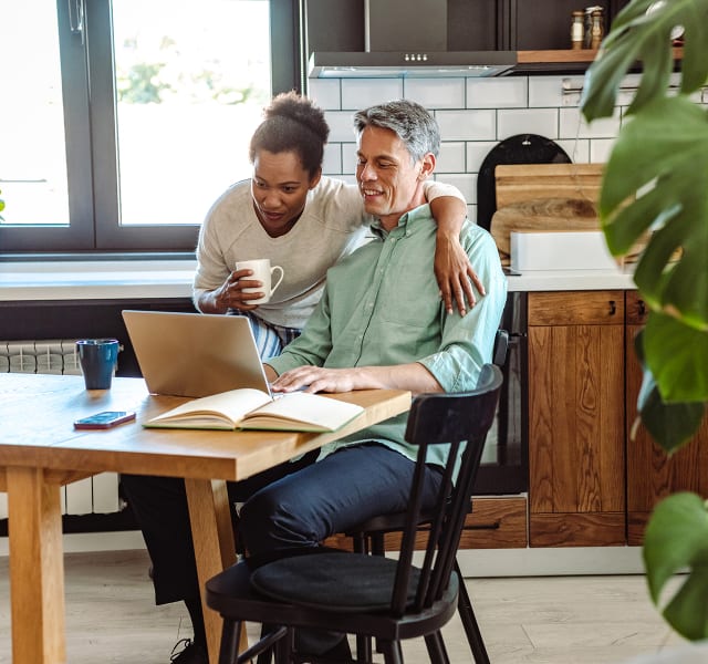 Couple in a kitchen looking at their computer and trying to sell their property themselves