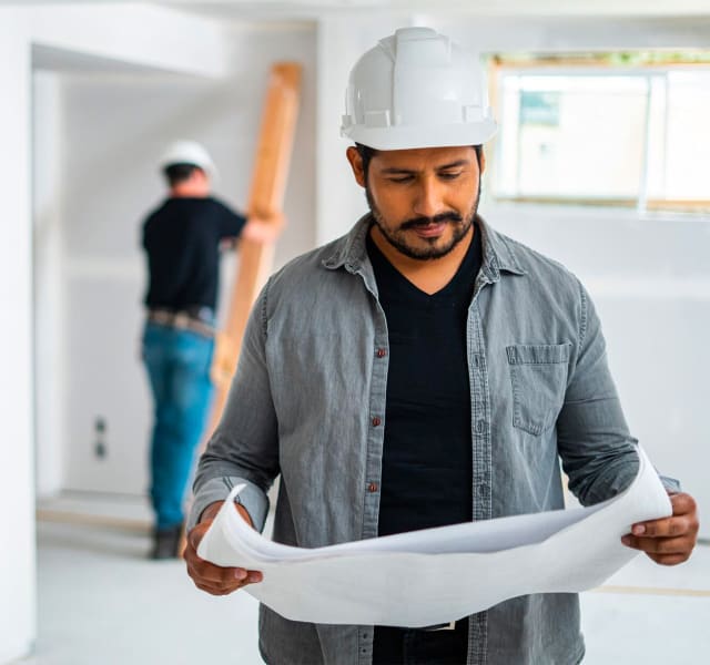 A verified contractor holding a plan on a RénoAssistance worksite.