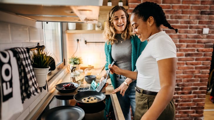 Deux femmes cuisinant dans un appartement
