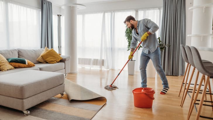 Homme passant la vadrouille dans le salon
