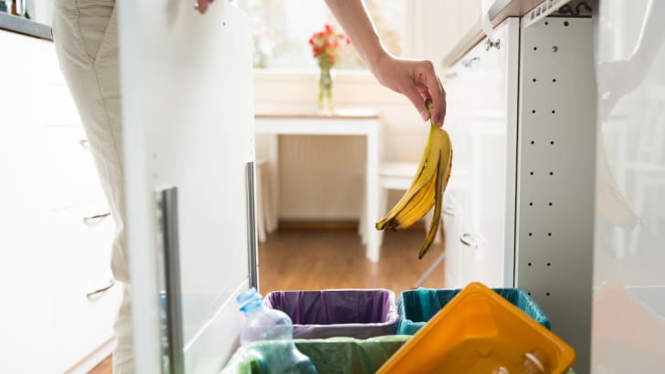Woman throwing banana peel in a garbage can