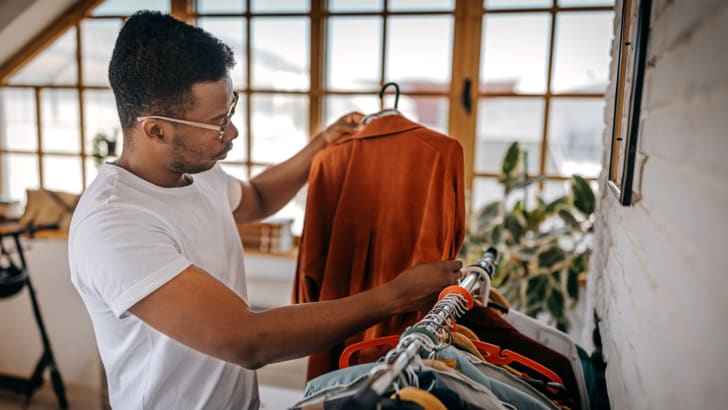 Homme examinant des vêtements sur un présentoir