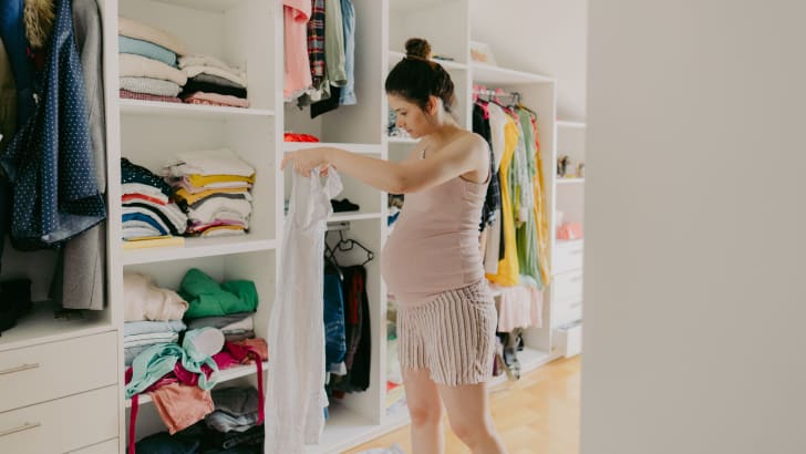Femme enceinte qui organise sa penderie