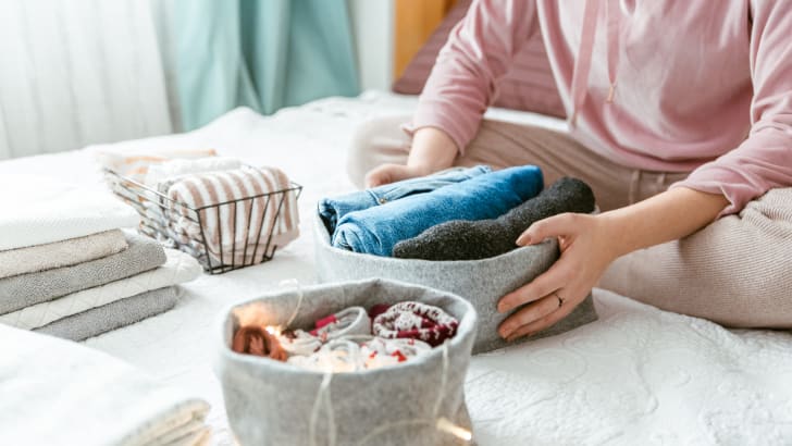 Femme plaçant des vêtements dans des bacs de rangement