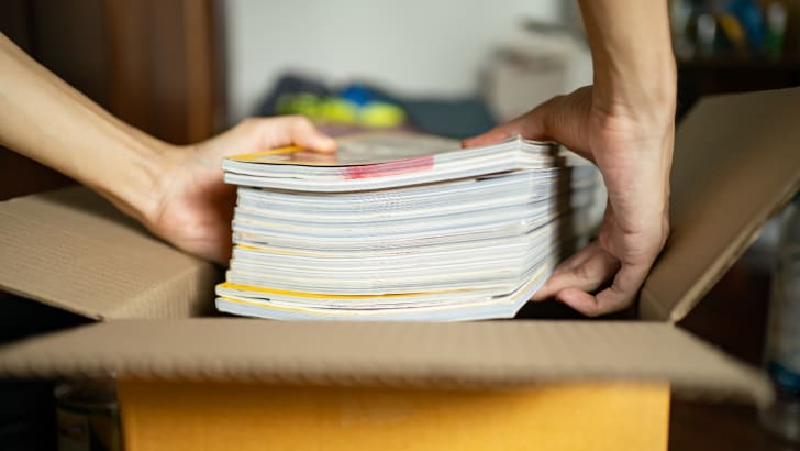 Personne emballant des magazines dans une boîte