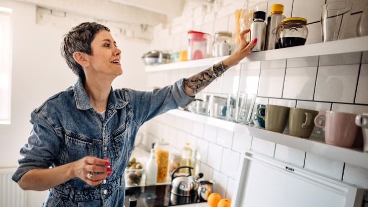 Femme organisant l'étagère de la cuisine