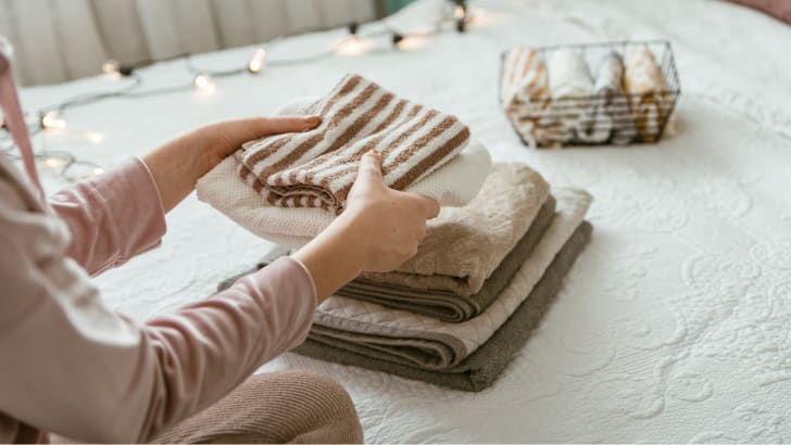 Femme pliant une pile de serviettes