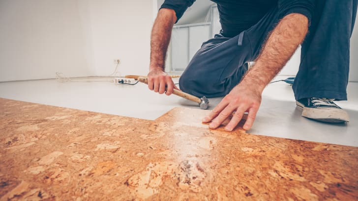 Homme installant un plancher de liège