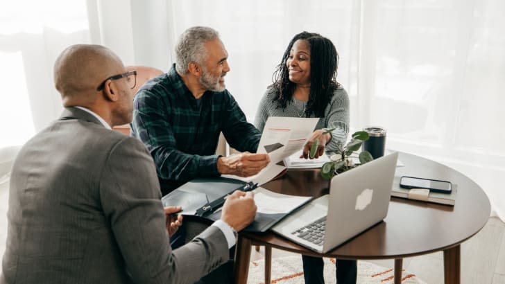 Groupe regardant des documents autour d'une table