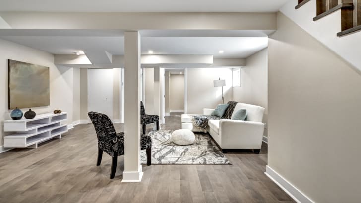 Sous-sol fini avec un espace salon invitant bien éclairé