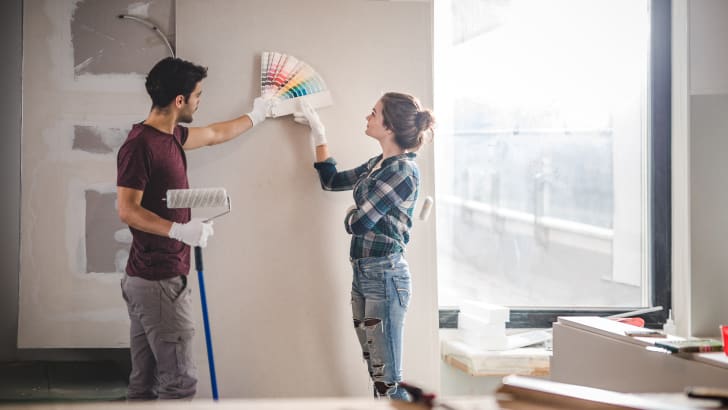 Jeune couple choisissant une couleur pour le mur de leur maison