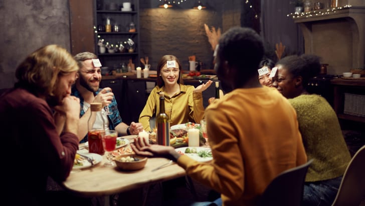 Groupe d'amis jouant aux devinettes pendant un souper de L’Action de grâce