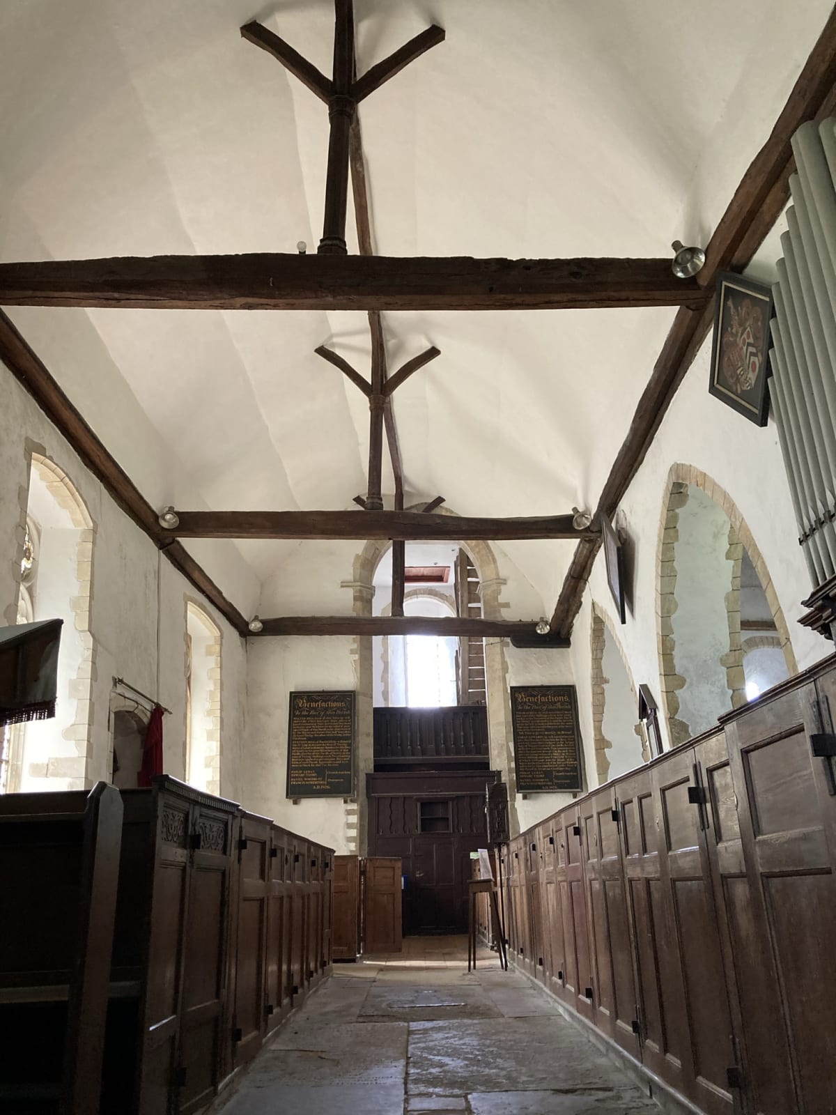 The view of the church interior from the east, looking down the nave at the tower arch and window