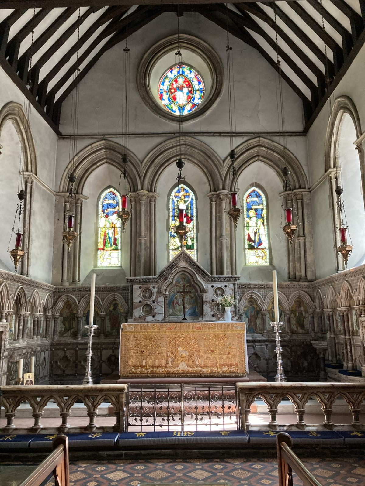 The view of the high alter surrounded by beautifully carved marble which was added during Matthew Woodward’s restorations. In the bottom left-hand corner you can see two candles and a small portrait. These stand next to the reliquary of St Eanswythe.