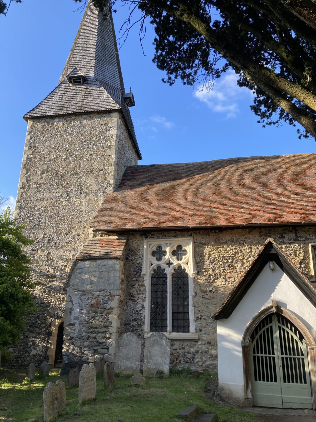 A view of the church’s main entrance and porch, with better view of the tower, and greater detail of the style of windows mentioned