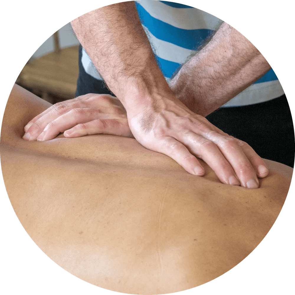 The massage therapis using their hands to massage a patient's back