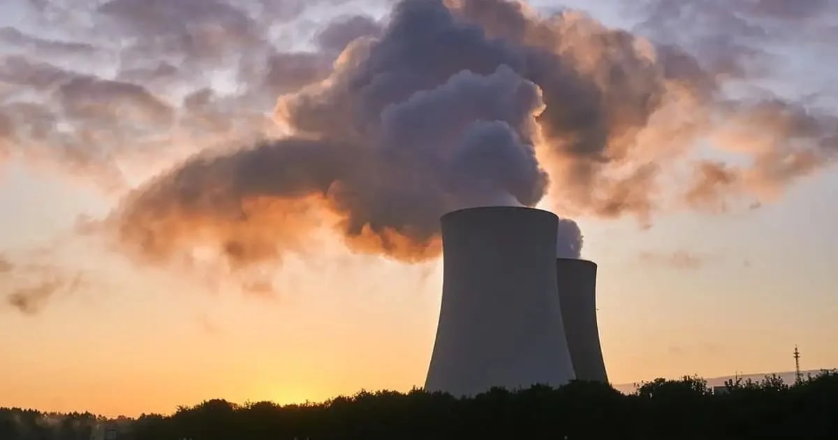 Torres de enfriamiento de una planta nuclear con grandes nubes de vapor saliendo al atardecer