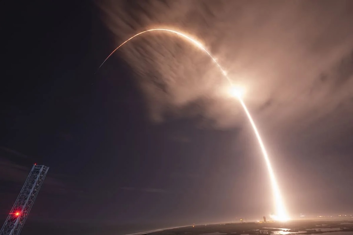 El Falcon 9 iluminando el cielo nocturno mientras despega, dejando una estela de luz en su trayectoria de ascenso.