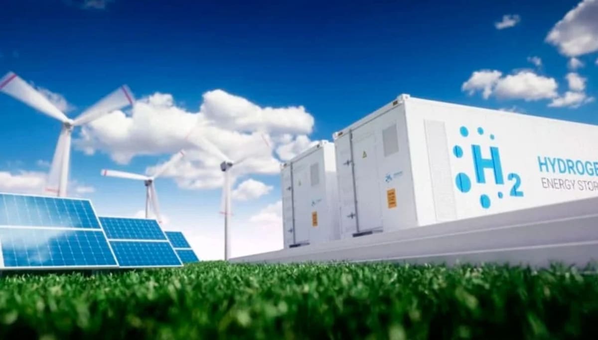 Planta de almacenamiento de hidrógeno verde junto a paneles solares y aerogeneradores, representando energías renovables y sostenibles.