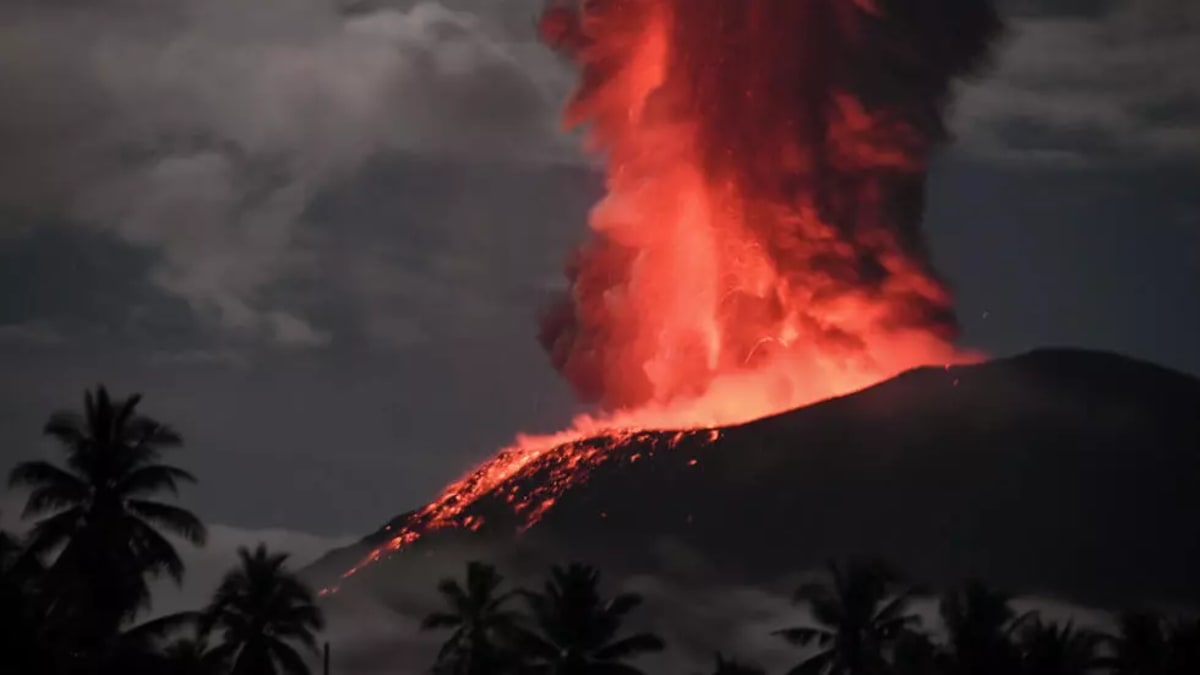 Una erupción del monte Ibu en Indonesia, con una gran columna de ceniza gris elevándose al cielo.
