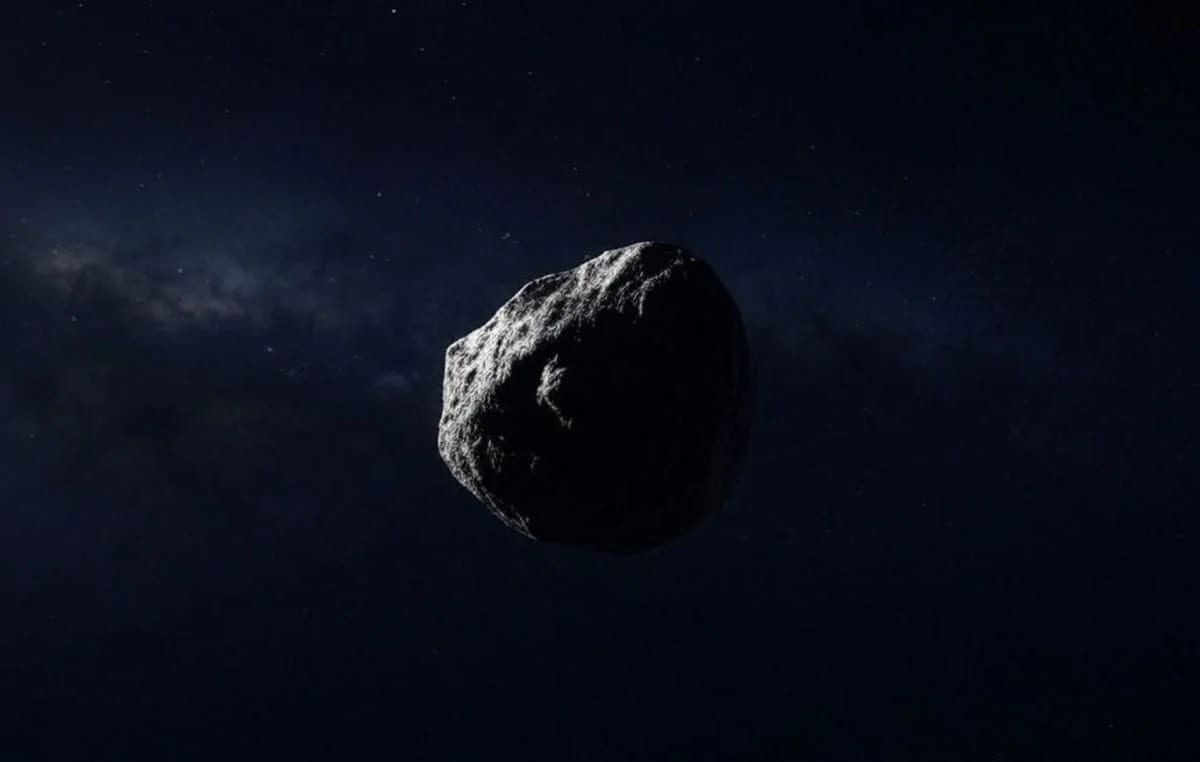 Asteroide rocoso flotando en el espacio profundo, iluminado parcialmente por la luz del Sol con un fondo de estrellas distantes.