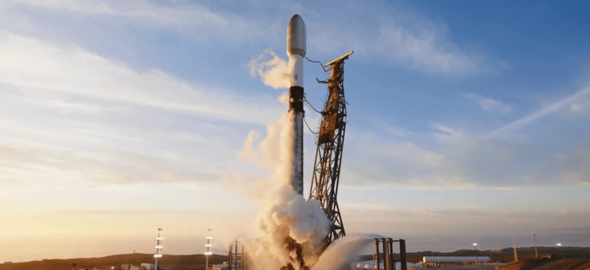 Cohete Falcon 9 de SpaceX en la plataforma de lanzamiento, rodeado de vapor de combustible durante la cuenta regresiva, listo para transportar satélites Starlink hacia la órbita terrestre baja al amanecer.