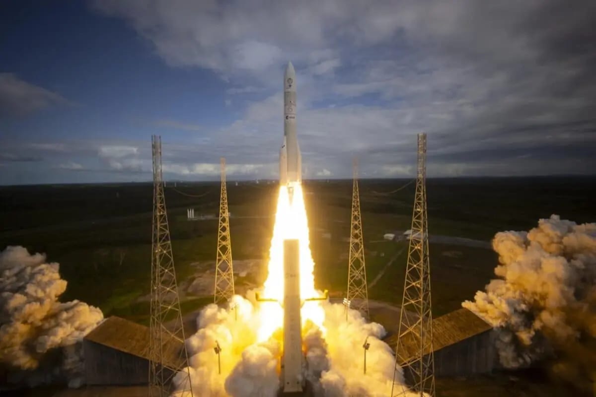 El cohete Ariane 6 despega desde el Puerto Espacial Europeo en la Guayana Francesa, iluminando el cielo con el fuego de sus propulsores mientras deja una estela de humo en su ascenso.