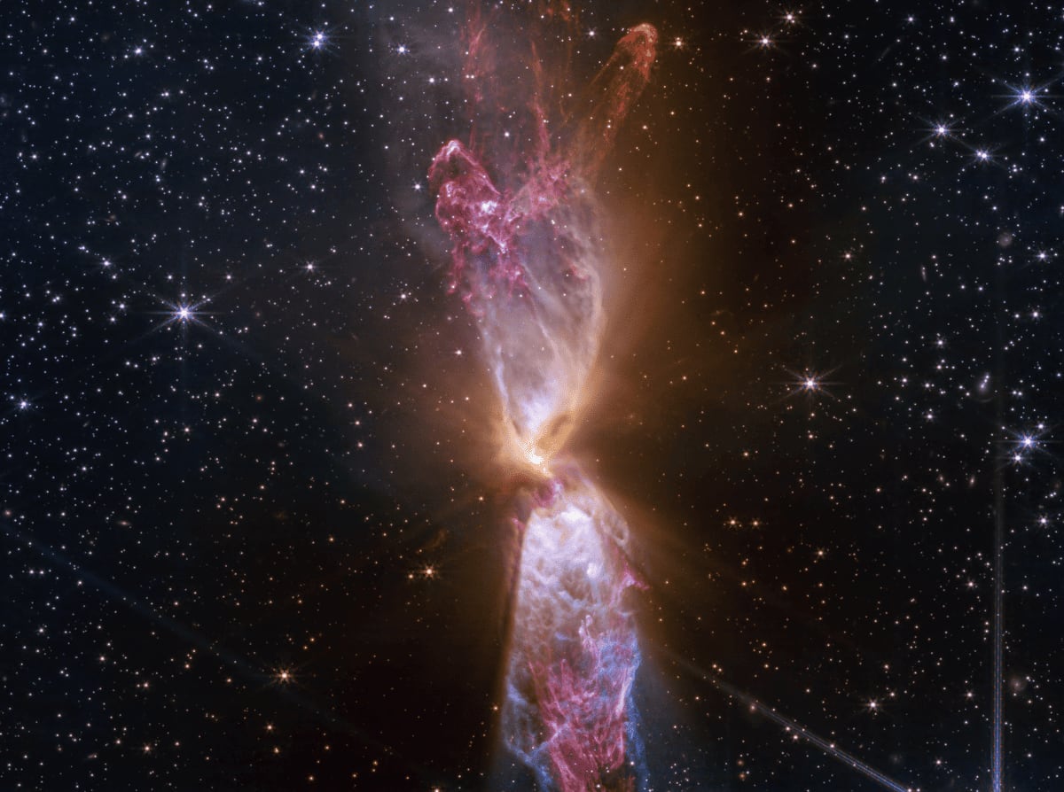 Imagen infrarroja del sistema estelar Lynds 483, captada por el telescopio Webb, mostrando eyecciones de gas y polvo en formación.