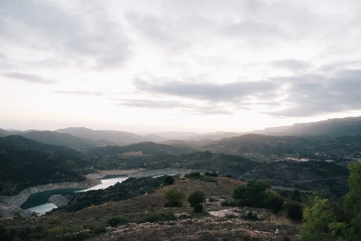 Vista panorámica del embalse de Siurana rodeado de montañas al atardecer en Catalunya