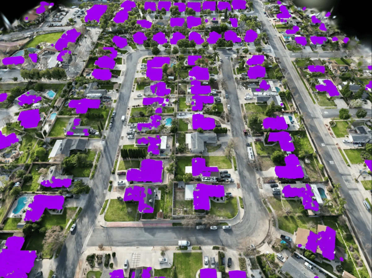 Visualización aérea con segmentación de IA resaltando viviendas en un vecindario suburbano.