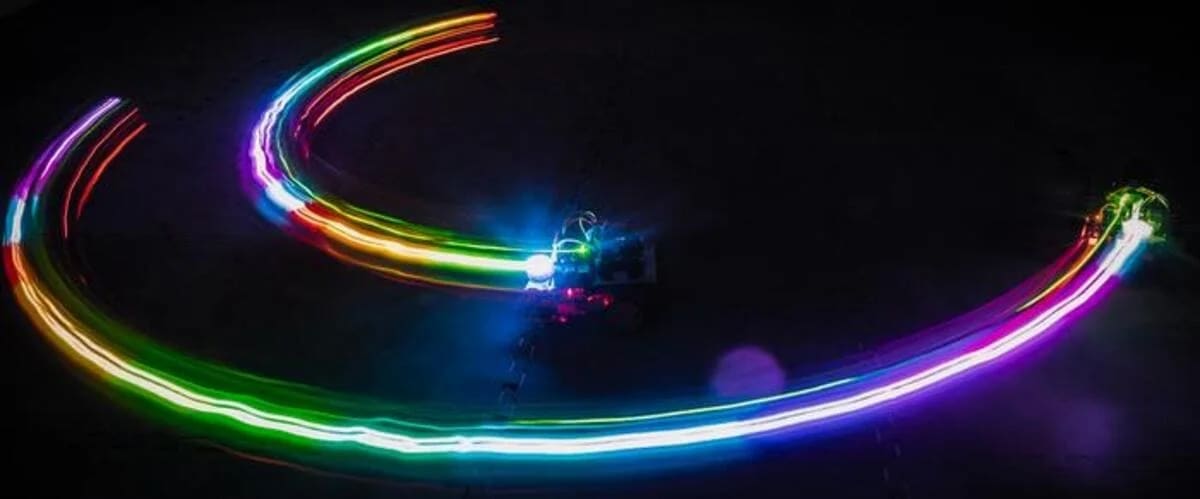 Trazas de luz dejadas por robots que simulan patrones de cardumen