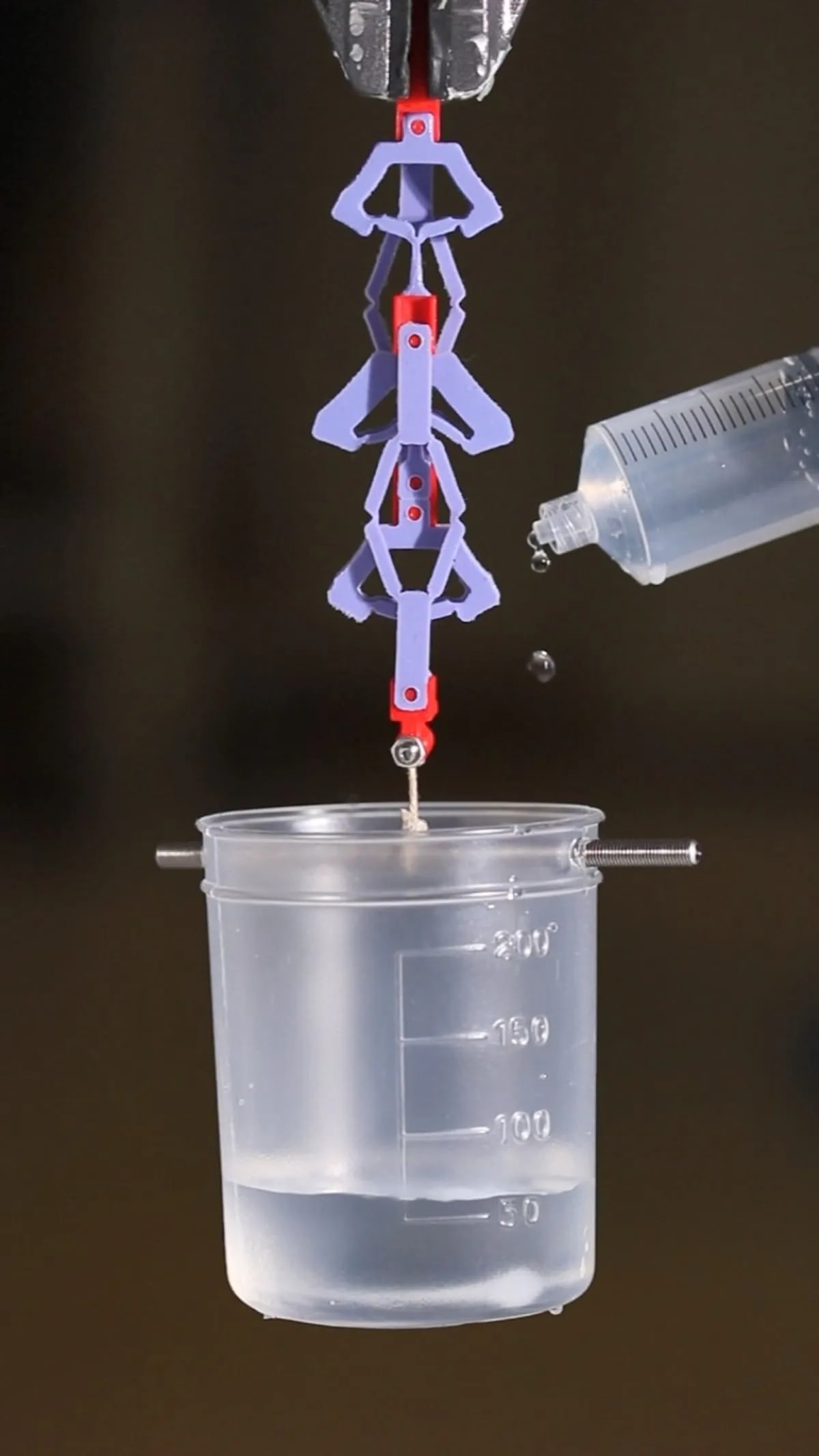 Material de contragolpe levantando una copa tras agregar peso mediante gotas de agua