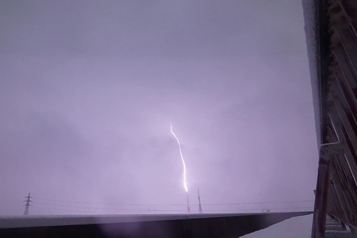 Un líder positivo ascendente emana de una torre de transmisión y genera un destello de rayos gamma terrestre descendente