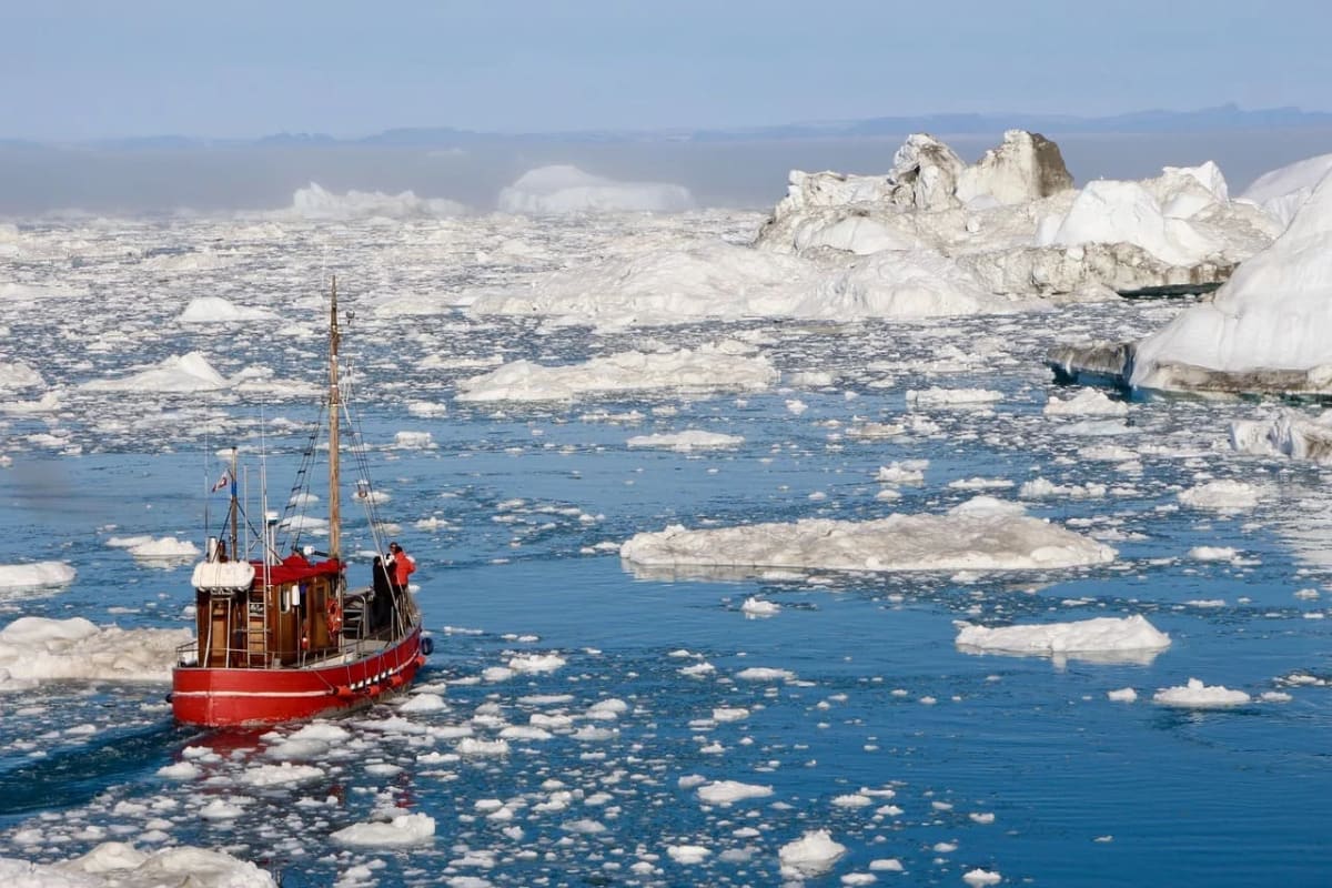 Barco navegando entre bloques de hielo en el Ártico