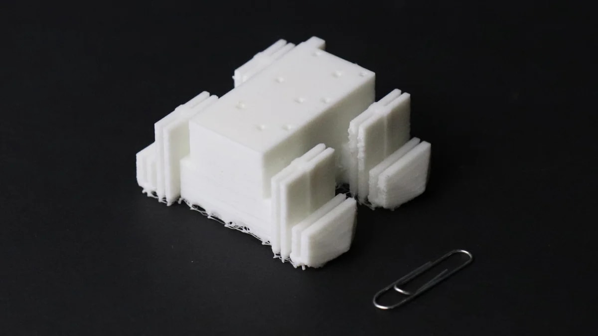 Robot blando a escala junto a un clip