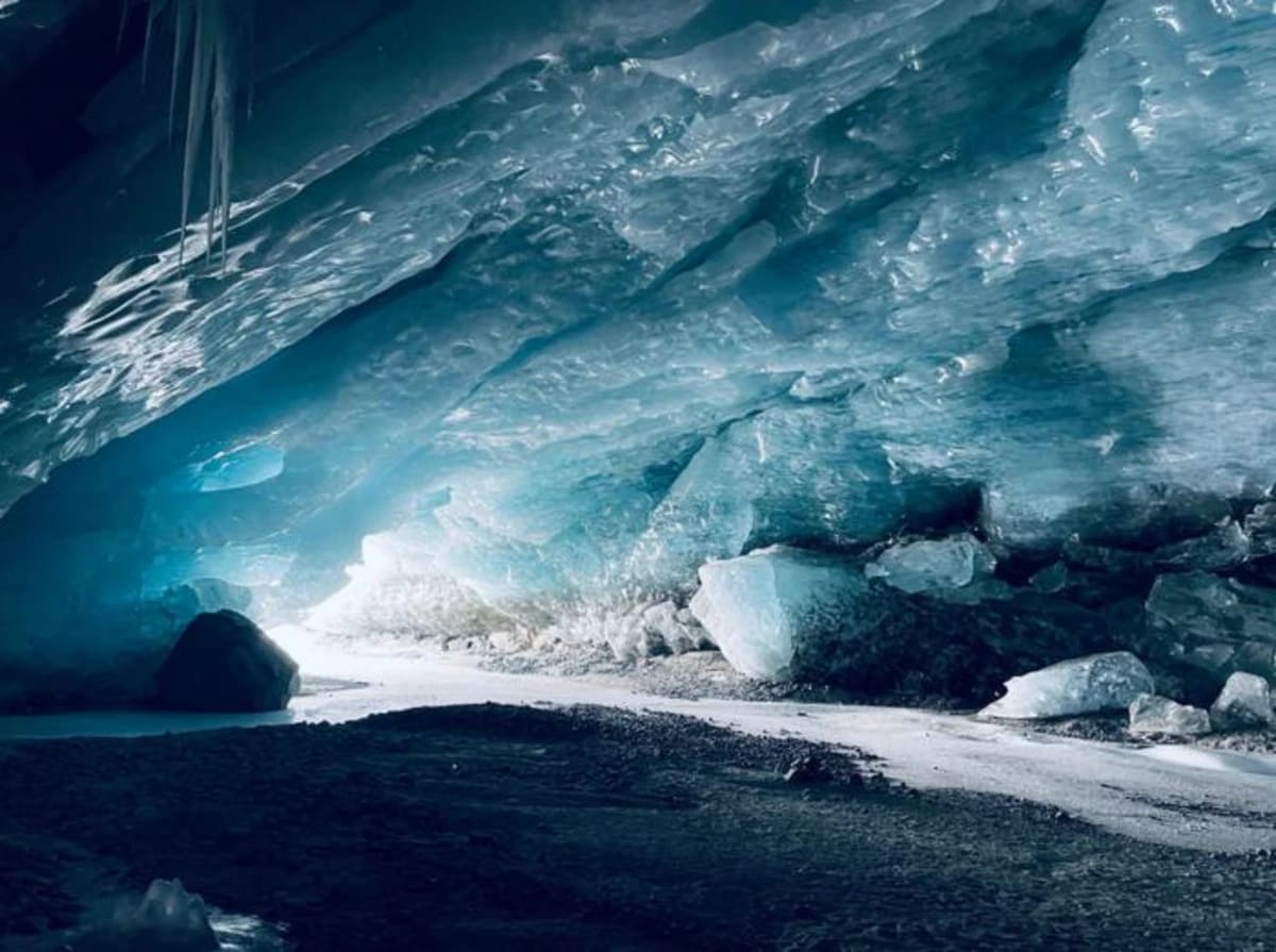 Cueva de hielo en el glaciar Morteratsch-Pers, Suiza, con agua de deshielo emergiendo en 2023