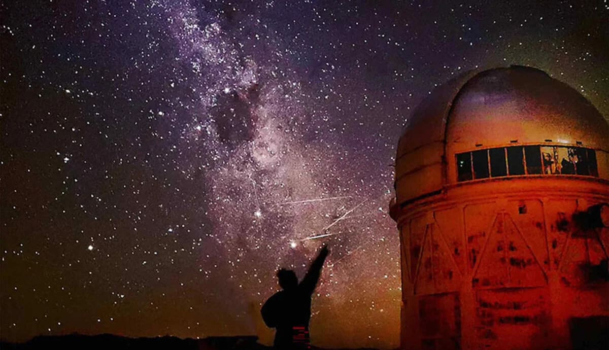 Vía Láctea sobre el Observatorio Interamericano de Cerro Tololo en Chile, silueta de Nicole Firestone en primer plano
