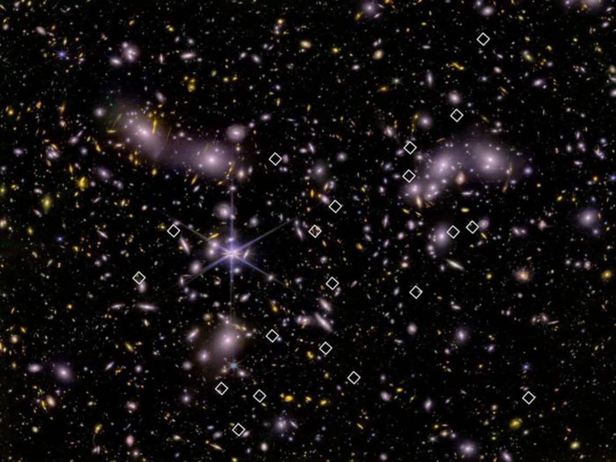 Diamantes blancos marcan galaxias jóvenes sobre imagen infrarroja del cúmulo Abell 2744