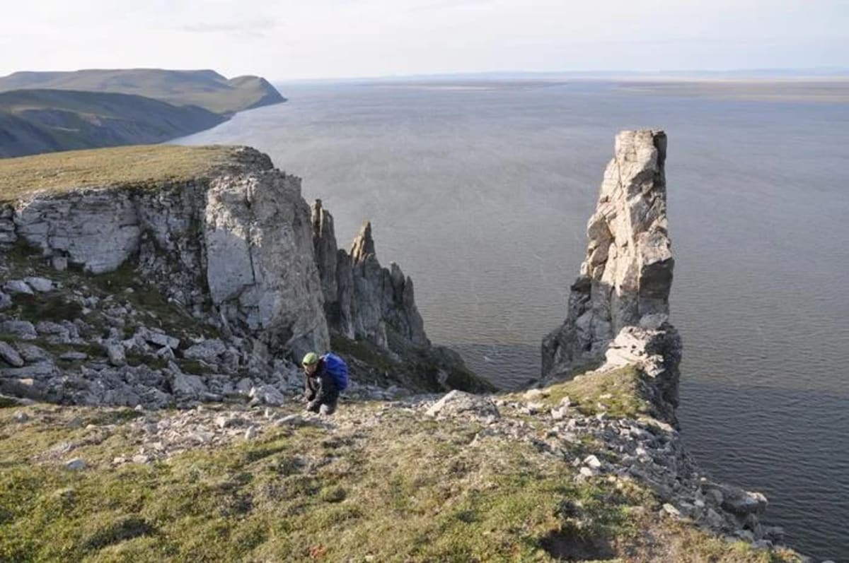 Investigadores trabajando en los acantilados de Taba-Baastakh, Siberia, recolectando muestras geológicas.