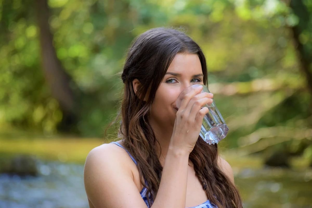 Mujer joven bebiendo agua