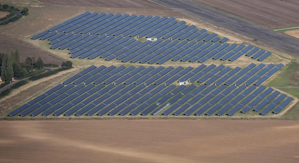 Vista aérea de una granja de paneles solares rodeada de campos agrícolas
