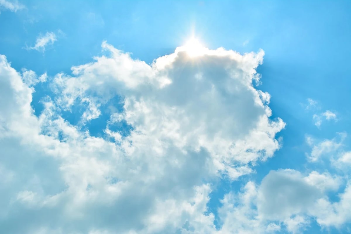 Cielo azul con nubes blancas iluminadas por el sol
