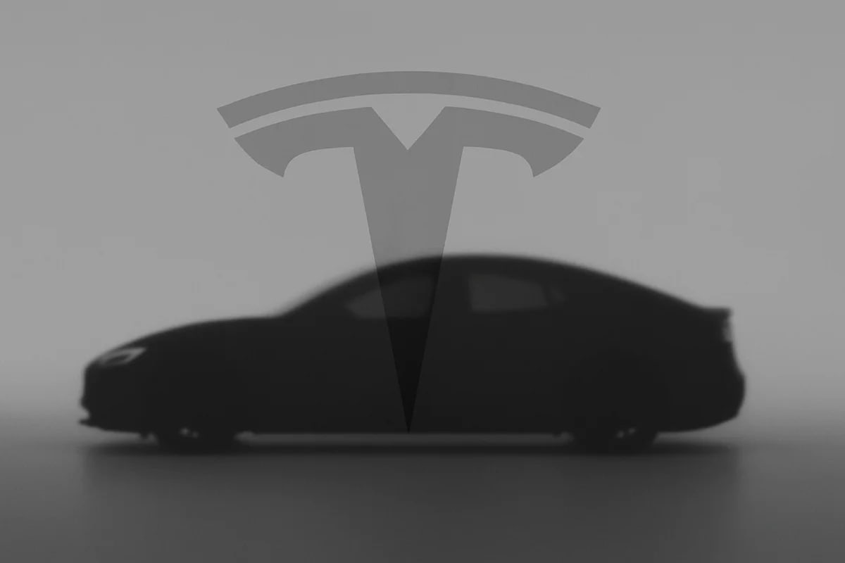 Silueta oscura de un coche eléctrico Tesla sobre fondo gris