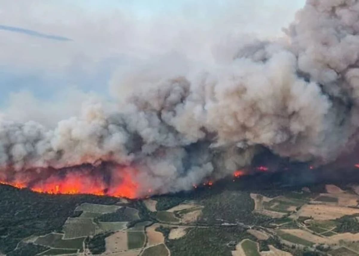 Gran incendio forestal en Corbières, sur de Francia, con humo denso y llamas avanzando hacia campos y colinas cercanas a la frontera con España