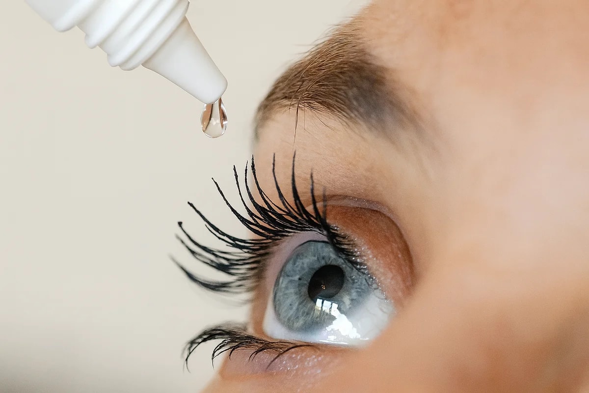 Ojo azul con una gota de colirio a punto de aplicarse