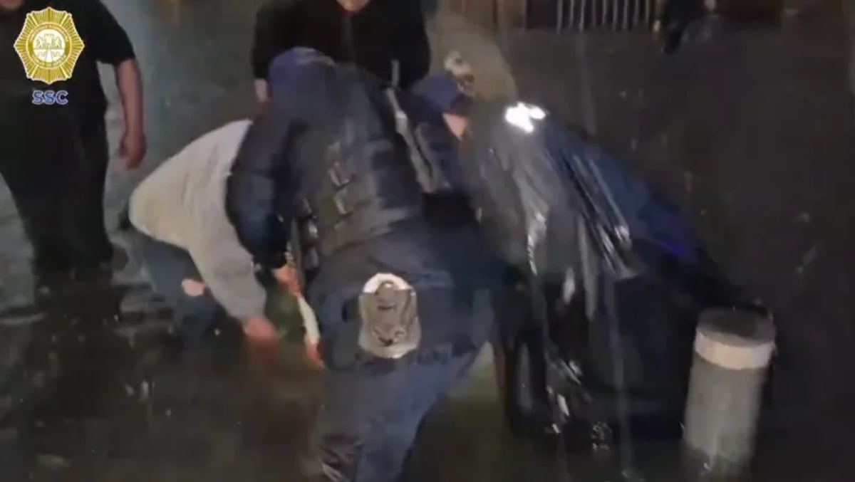 Policías de la SSC limpiando una alcantarilla durante una inundación en Ciudad de México