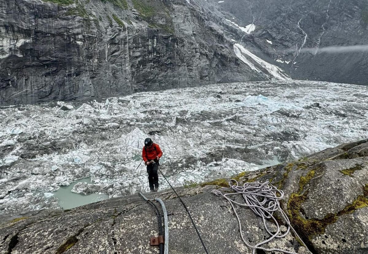 Investigador descendiendo por una pared rocosa cerca del glaciar Mendenhall en Alaska