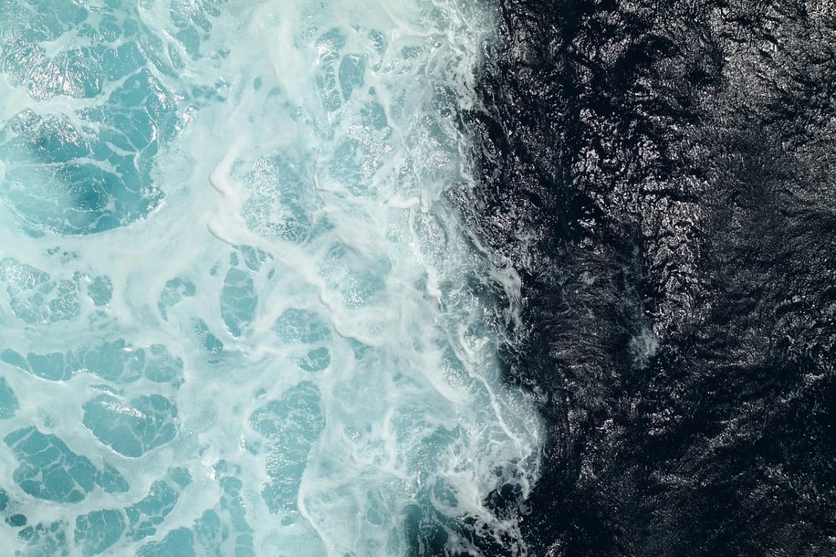 Vista aérea de la unión entre aguas claras y aguas profundas en el océano