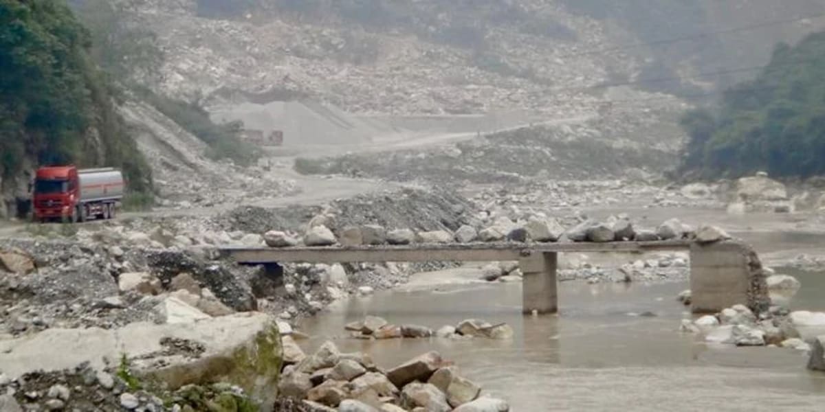 Puente destruido y escombros arrastrados por la inundación en el río Min tras un deslizamiento de tierra