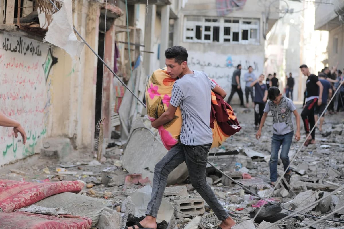 Personas huyen entre escombros tras un ataque en Gaza